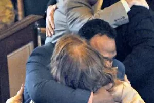 an exonerated Gustavo Ramirez hugs his grandmother as his father, Gustavo Sr., embraces defense lawyer J. Drew Segadelli