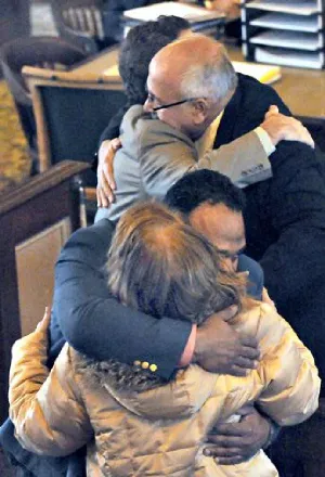 an exonerated Gustavo Ramirez hugs his grandmother as his father, Gustavo Sr., embraces defense lawyer J. Drew Segadelli